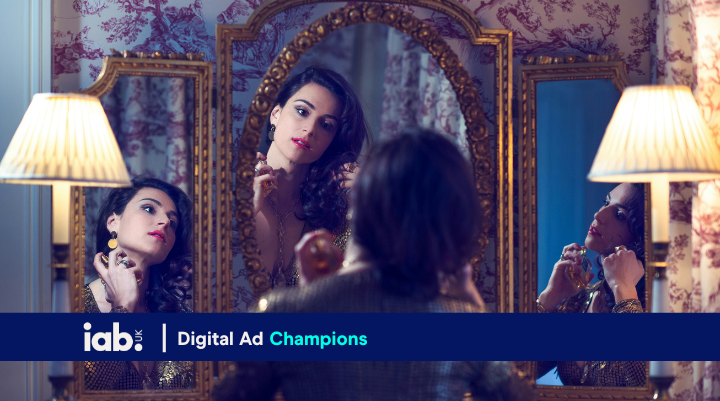 someone spraying perfume whilst looking in the mirror 